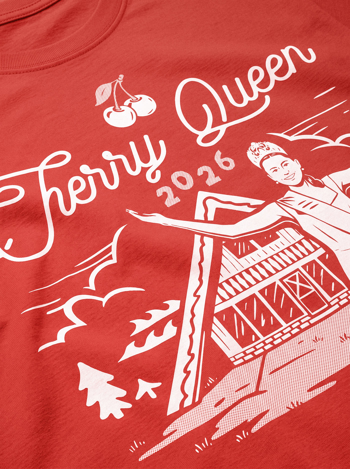 Close detail of the printed Cherry Queen 2026 illustration on a red shirt