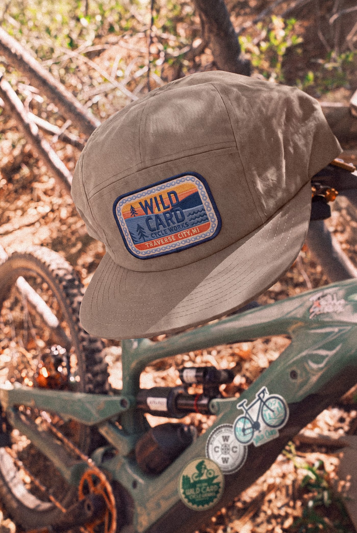 A tan hat with the Wild Card patch hanging from the handlebars of a mountain bike